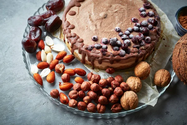 Chocolate vegan cake with different nuts, dates and carob