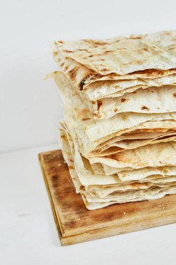 düz ızgara pide üzerinde beyaz bir arka plan ile bir ahşap kesme tahtası.