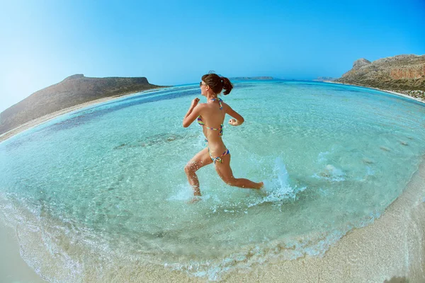 Nainen juoksee rannalla — kuvapankkivalokuva