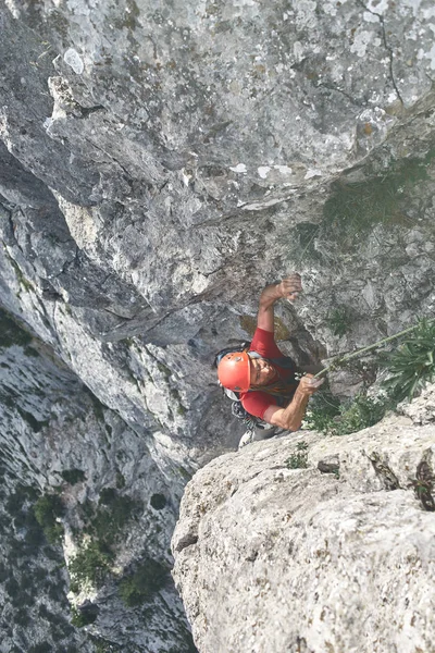 Człowiek alpinista wspina się na klifie — Zdjęcie stockowe