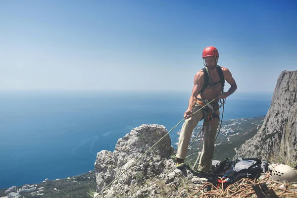 Человек скалолаз стоит на вершине скалы — стоковое фото
