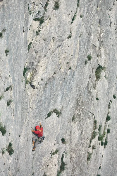 Viejo hombre escalador de roca sube en el acantilado — Foto de Stock