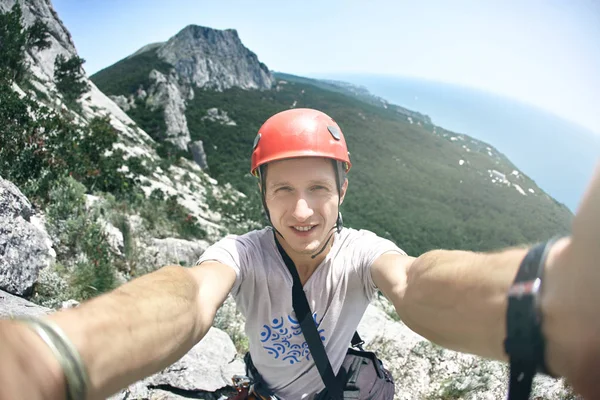 Man climber makes selfie with mountains and sea background — Stock Photo, Image