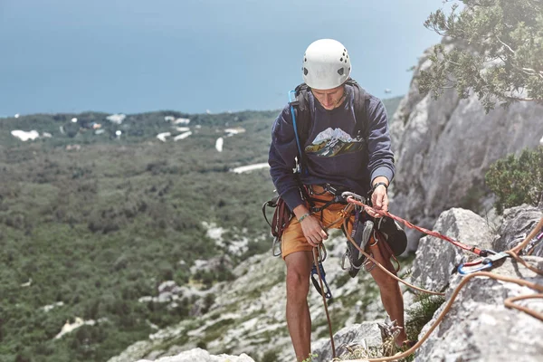 Adam kaya tırmanışçısı uçurumun tepesinde ve bir ortak belays — Stok fotoğraf