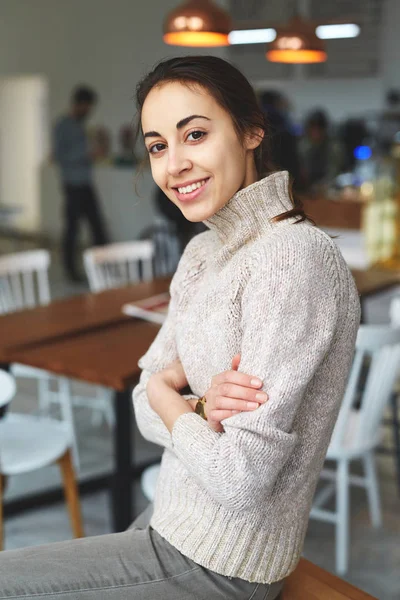 Young smiling woman sits in cafe — Stock Photo, Image