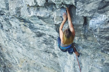 kadın dağcı cliff üzerinde tırmanıyor