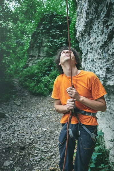 A man insures climber through a belay device.