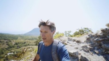 Yakın çekim geniş açı yavaş çekim selfie portresi. Yaz günü dağ sırtında koşan genç yetişkin erkek iz koşucusu..