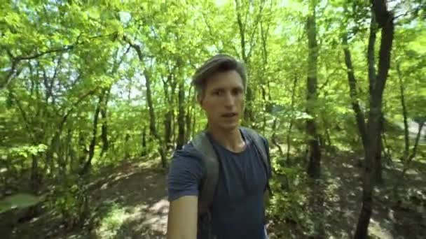 Closeup wide angle selfie portrait of young adult man fast walking in forest at summer day — Stock Video