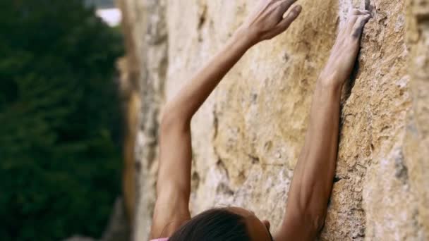 Vrouwenhanden reiken en houden rotsen vast op een gele klif — Stockvideo
