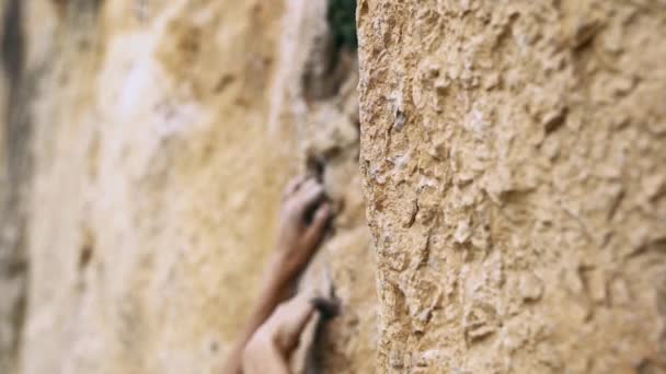 Le mani delle donne che raggiungono e tengono la roccia su una scogliera gialla — Video Stock