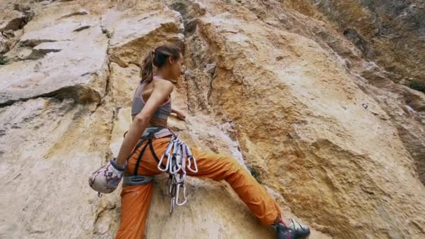 Ángulo amplio vista inferior Mujer en forma joven escalada en roca en la ruta deportiva al aire libre — Vídeo de stock