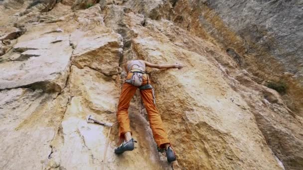 Ángulo amplio vista inferior Mujer en forma joven escalada en roca en la ruta deportiva al aire libre — Vídeos de Stock