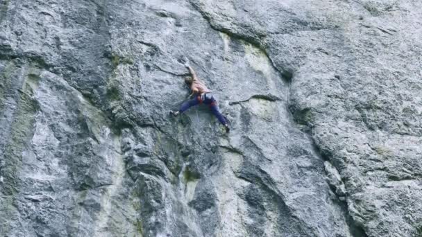 Vista posterior fuerte musculoso hombre escalador escalada en la ruta deportiva al aire libre en un acantilado vertical — Vídeo de stock