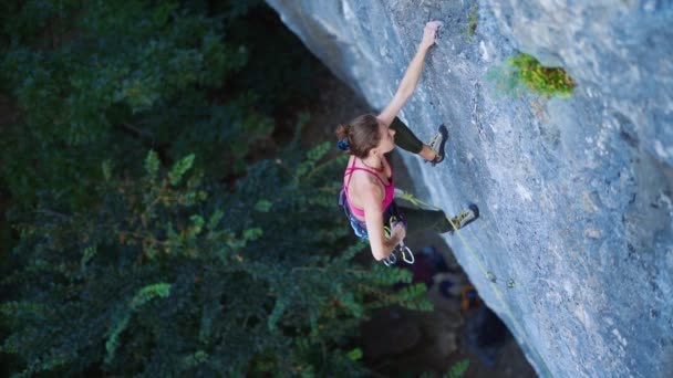 Mulher escalando na rota do esporte difícil, alpinista faz um top, rota de acabamento e cortando corda no último quickdraw — Vídeo de Stock