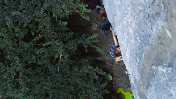 Mulher escalando na rota do esporte difícil, alpinista faz um movimento difícil — Vídeo de Stock