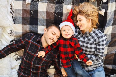 Noel ailesi evde birlikte vakit geçirir, evde yatakta uzanır..