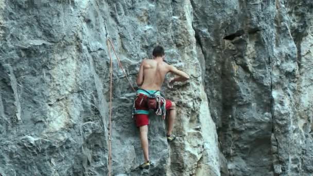 Uomo rockclimber appeso a una corda su una dura via sportiva, mani di riposo e gesso . — Video Stock