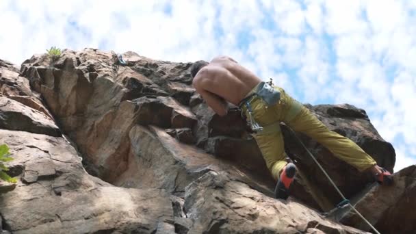 Zeitlupe kletternde Momente und Details. Sportlicher Bergsteiger mit nacktem Oberkörper klettert auf Klippe — Stockvideo