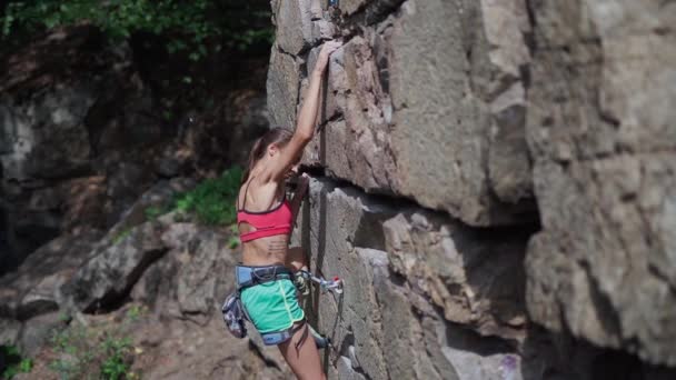 Joven delgado muscular mujer escalador escalada en la ruta deportiva difícil, escalador hace un movimiento duro . — Vídeos de Stock