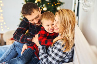Mutlu aile anne, baba ve çocuk evde birlikte vakit geçiriyorlar..