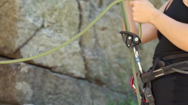 Woman climber belaying partner with belaying device. — Stock Video