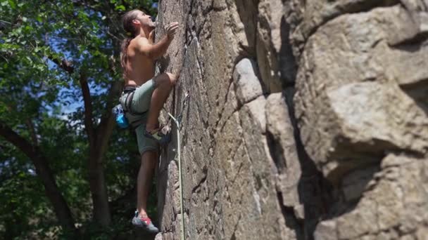 Jovem homem muscular rockclimber escalada na rota do esporte difícil, procurando, atingindo e segurando . — Vídeo de Stock