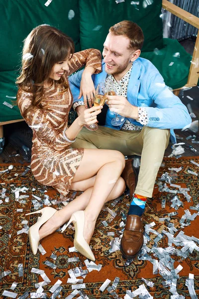 年轻貌美的情侣们在家里开派对时，一边喝着香槟一边碰杯，看上去很开心. — 图库照片