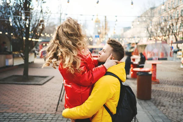 Joven pareja apasionada divirtiéndose juntos y buscando feliz, joven guapo llevando a su novia mientras camina por la calle . — Foto de Stock