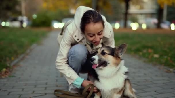 Όμορφη χαμογελαστή γυναίκα με τα πόδια χαριτωμένο σκυλί στη φύση — Αρχείο Βίντεο