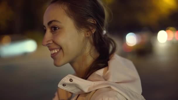 Bela sorridente jovem mulher andando ao ar livre noite cidade. — Vídeo de Stock