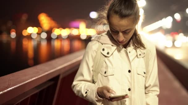 Mujer prety usando teléfono inteligente caminando en la ciudad de noche — Vídeos de Stock