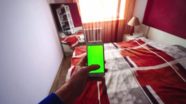 Pov, mužská ruka držící smartphone s prázdnou zelenou obrazovkou chromakey — Stock video