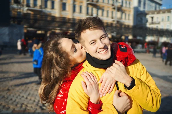 Ritratto all'aperto di giovani coppie felici innamorate trascorrendo del tempo insieme in città. donna baci in guancia il suo ragazzo smilling. — Foto Stock