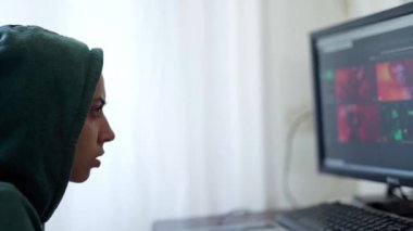 Yan bakış kadın programcı, kapüşonlu bilgisayar kullanan serbest bilgisayar korsanı.