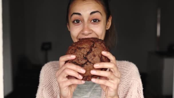 portrét šťastné usmívající se ženy jíst velké čokoládové sušenky