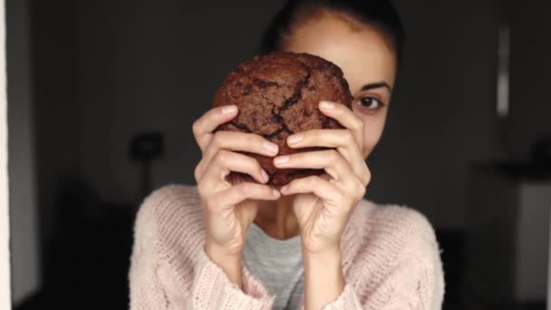 Portret van een vrolijke lachende vrouw die grote chocoladekoekjes eet — Stockvideo