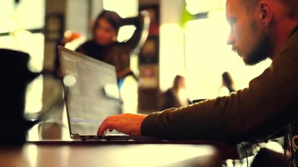Человек фрилансер сидит в кафе работает ноутбук — стоковое видео
