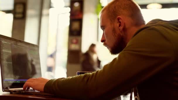 Άνθρωπος ελεύθερος επαγγελματίας κάθεται στο καφέ εργασίας laptop — Αρχείο Βίντεο