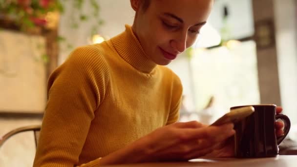 Telefone - jovem bela Mulher SMS SMS usando o aplicativo no telefone inteligente em caffee — Vídeo de Stock