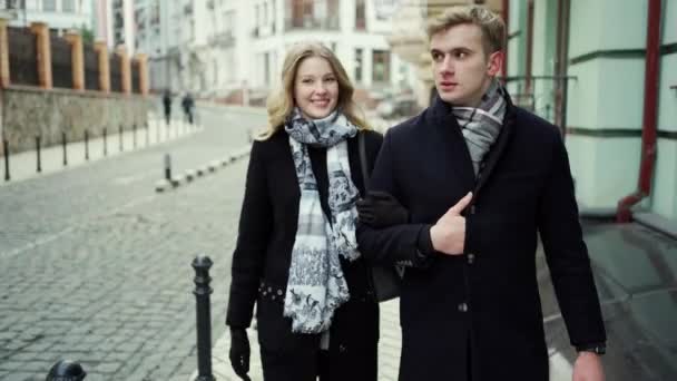 Elegant mooi blond paar lopen stad straat, kijken naar elkaar met glimlach en kussen — Stockvideo