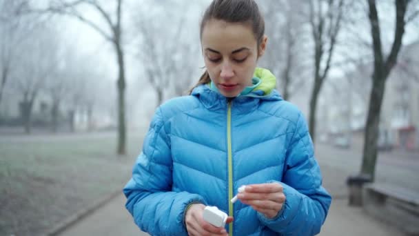 Jovem mulher atraente usando fones de ouvido sem fio — Vídeo de Stock