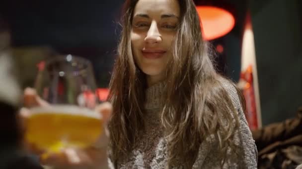 Gelukkig glimlachen aantrekkelijk vrouw met lang haar drinken bier in pub — Stockvideo