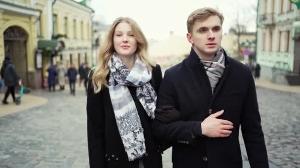 Jovem casal loira bonita andando rua da cidade, olhando um para o outro com sorriso . — Vídeo de Stock