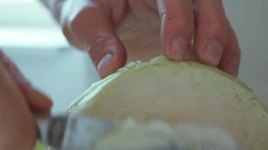 Son derece yakın çekim yavaş çekim adamı vejetaryen salatası için lahana bıçağıyla kesiyor.
