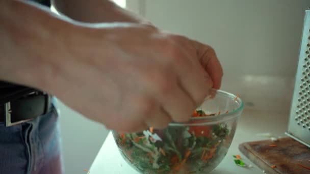Homem misturando legumes em uma tigela, cozinhando salada . — Vídeo de Stock