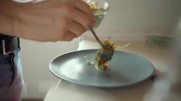 男人把新鲜蔬菜沙拉放在盘子里. — 图库视频影像