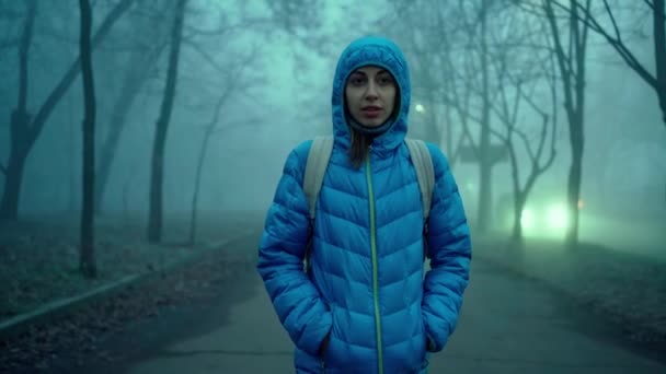 Jong sportief vrouw in blauw donsjas met kap en kleine stad rugzak — Stockvideo