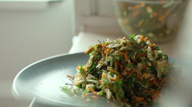 Yakın plan adam vejetaryen salatasına zeytinyağı ekliyor.