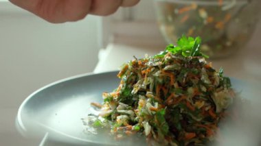 Yakın plan vejetaryen salatasına baharat ve kurutulmuş ot ekleme